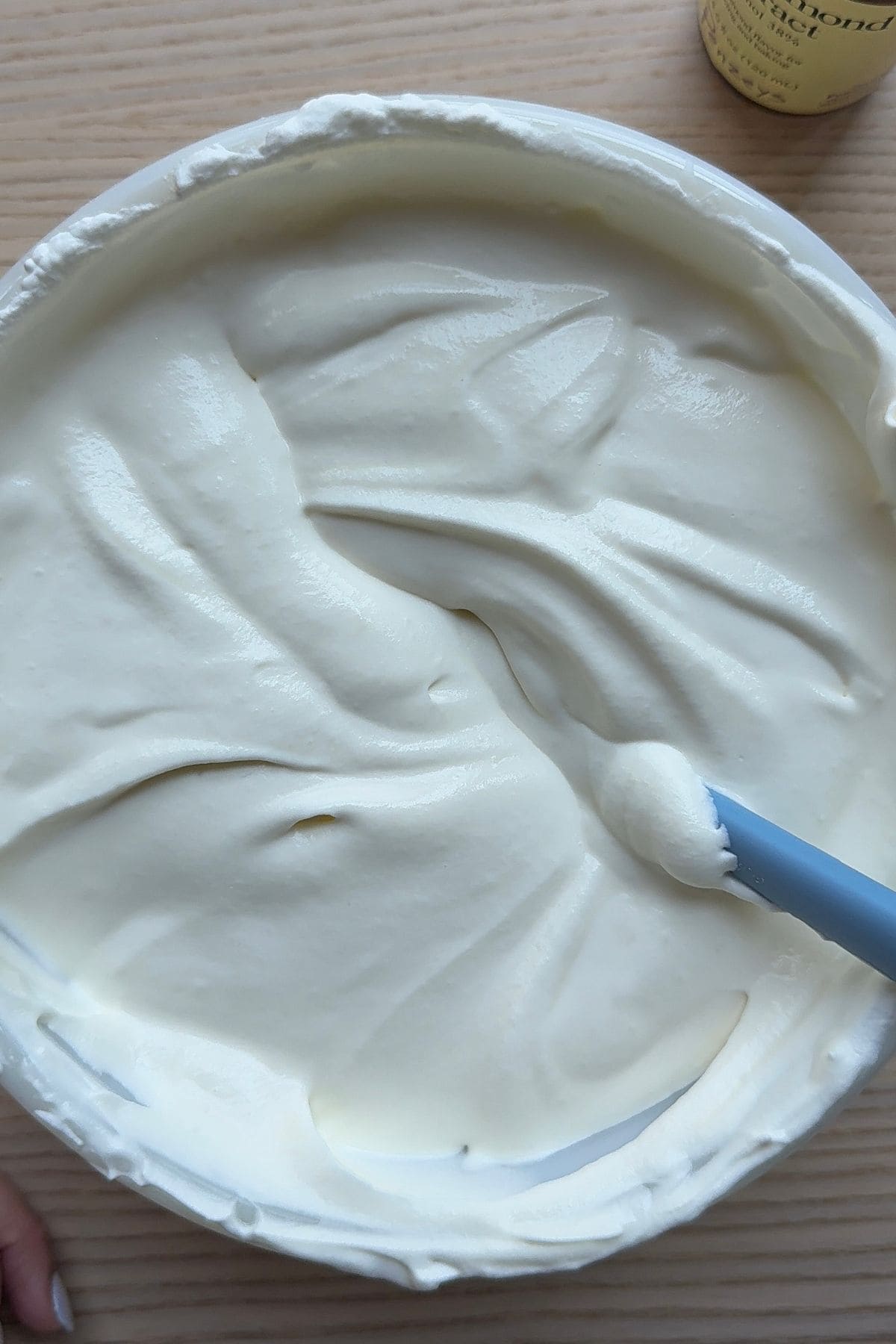 Whipped cream and sweetened condensed milk folded together in a large bowl.