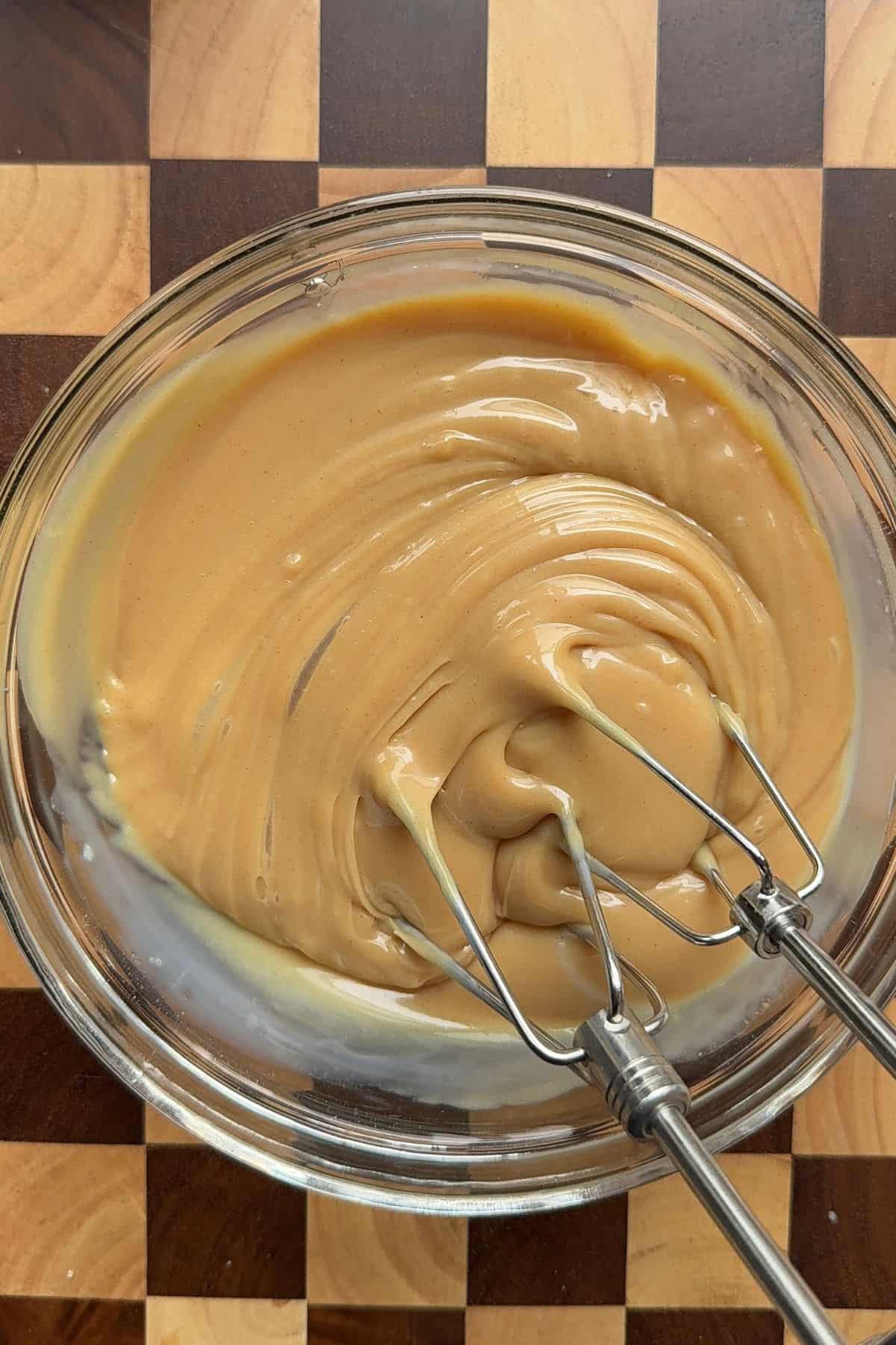 Sweetened condensed milk and peanut butter mixed together in a small bowl.