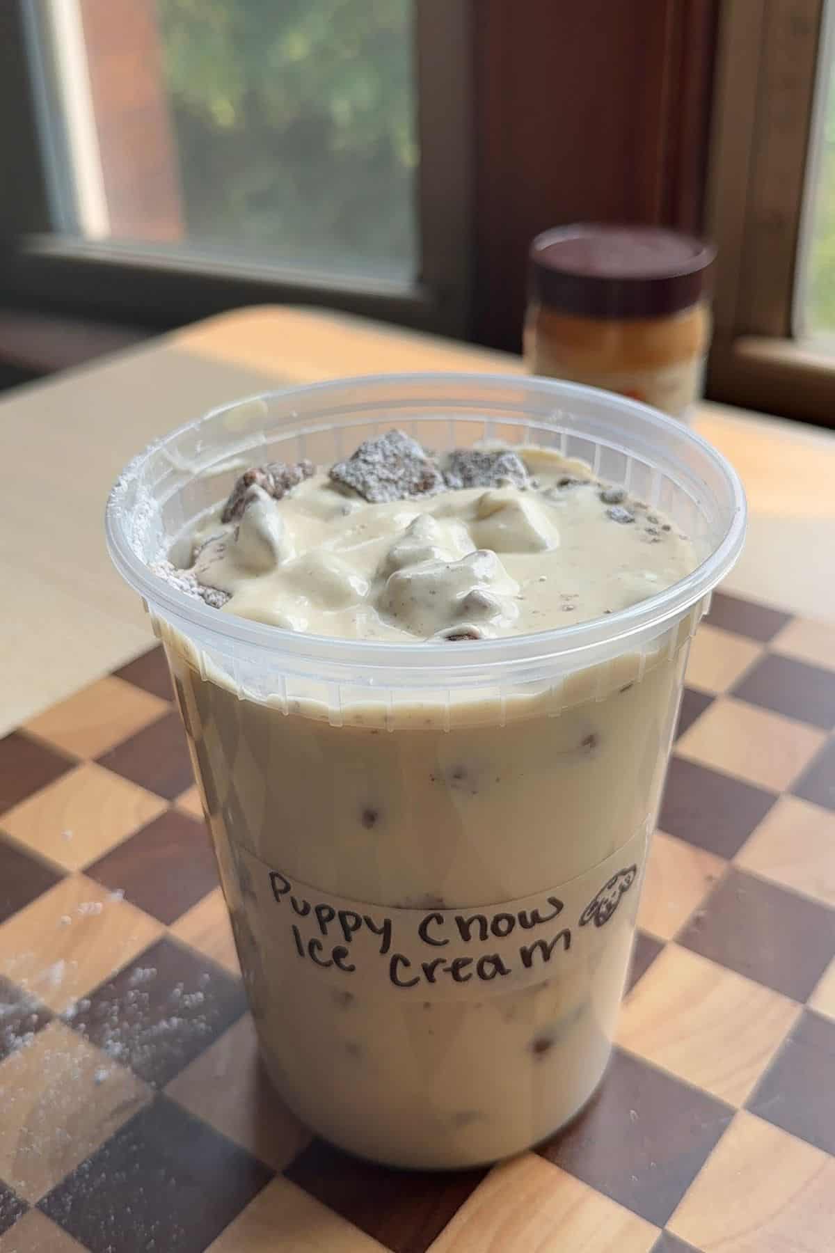 Ice cream in a deli container labelled "puppy chow ice cream".