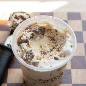 A close up of puppy chow ice cream in a deli container.