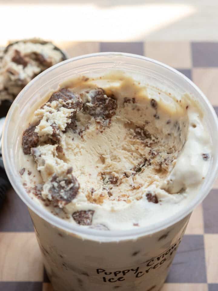A close up of puppy chow ice cream in a deli container.