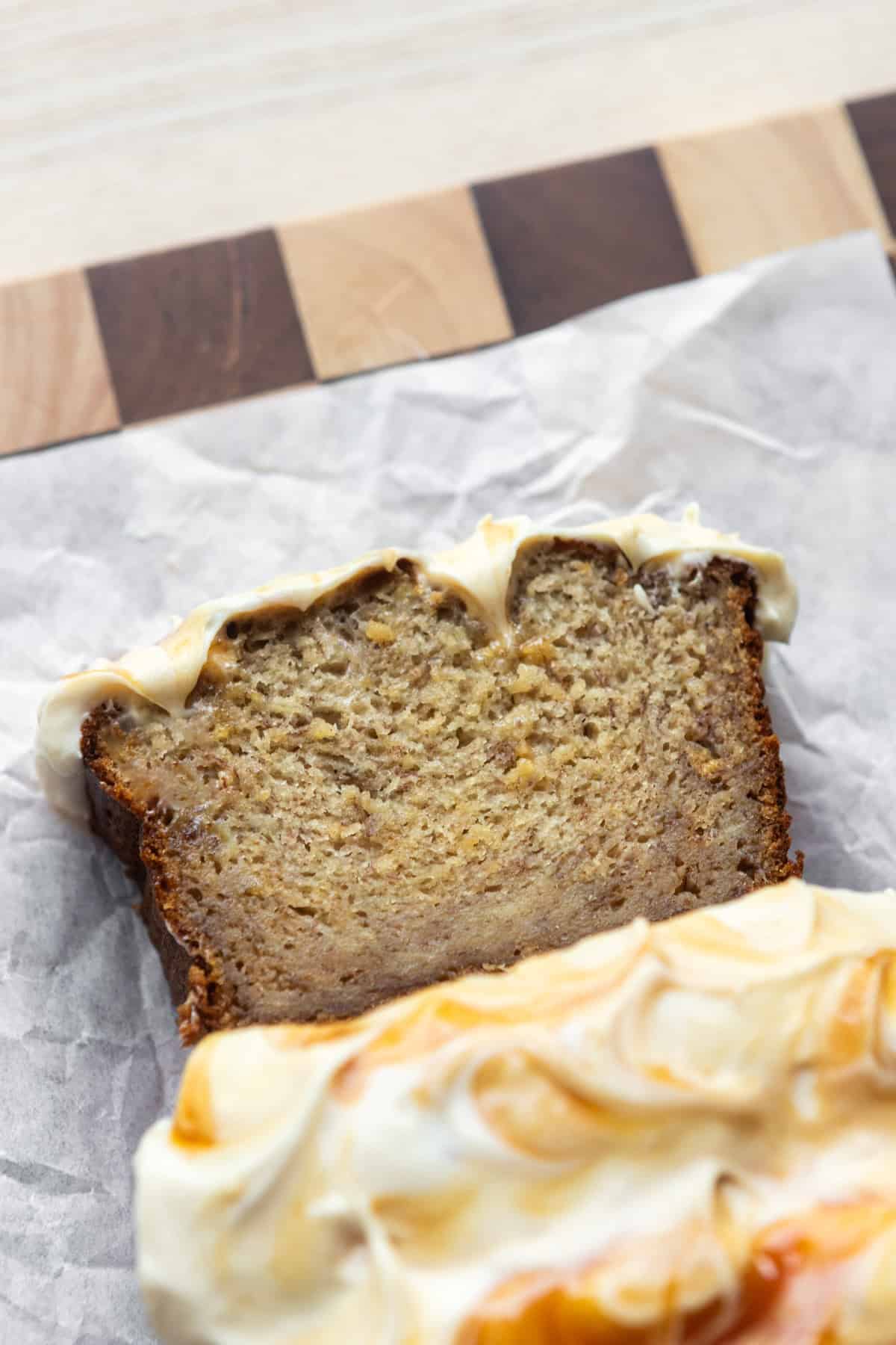 A slice of caramel banana bread on parchment paper.