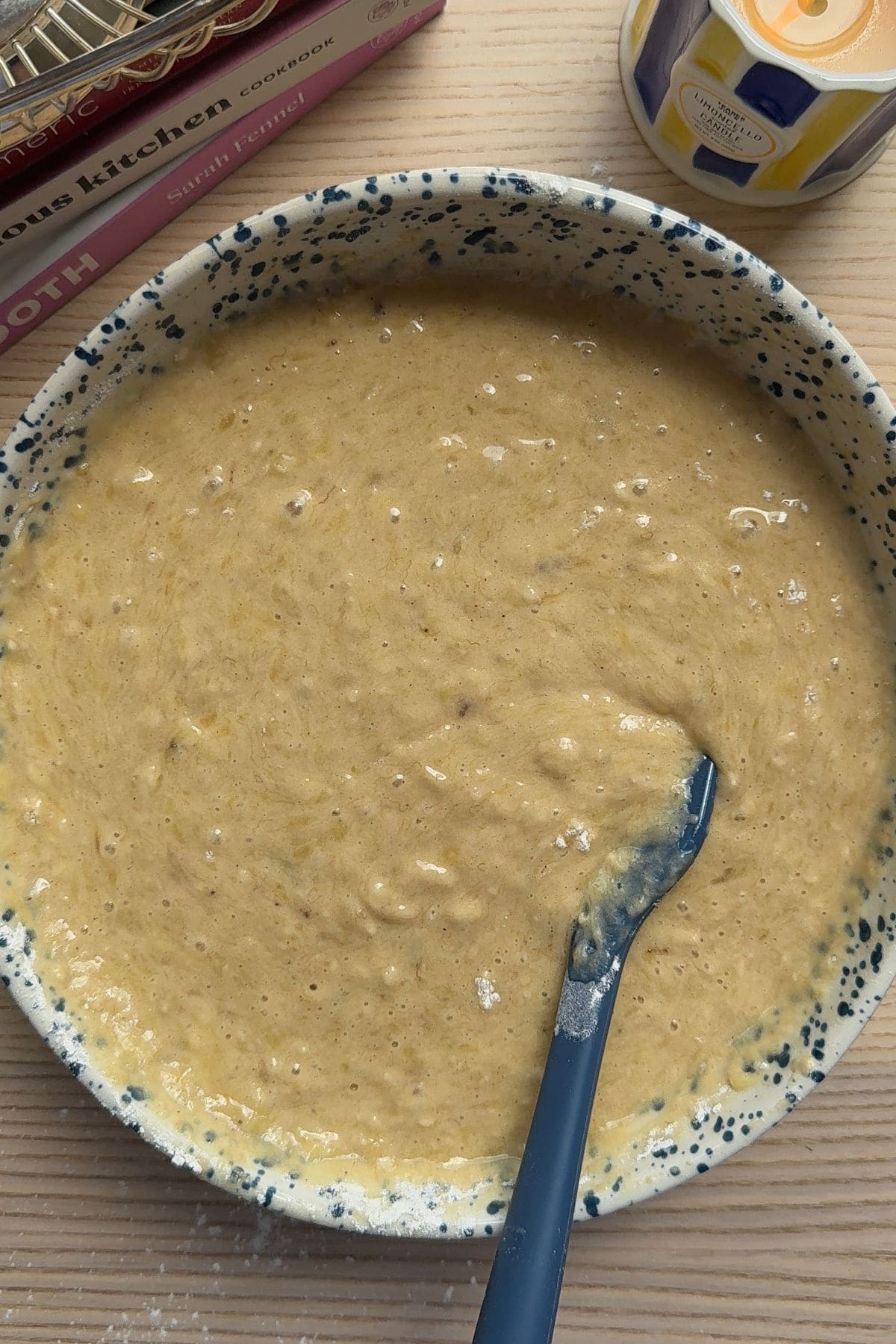 Banana bread batter in a large mixing bowl with a rubber spatula.