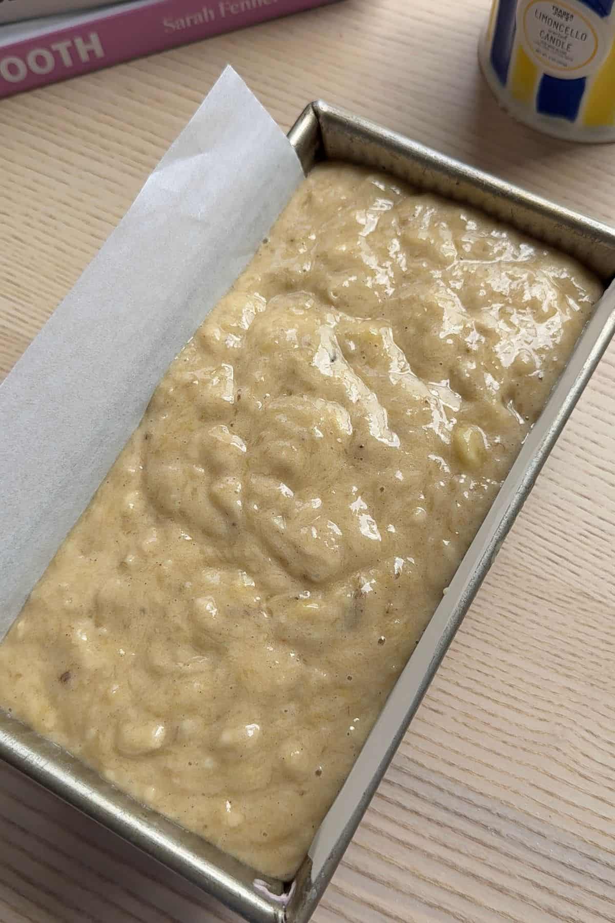 Unbaked banana bread in a lined loaf pan.