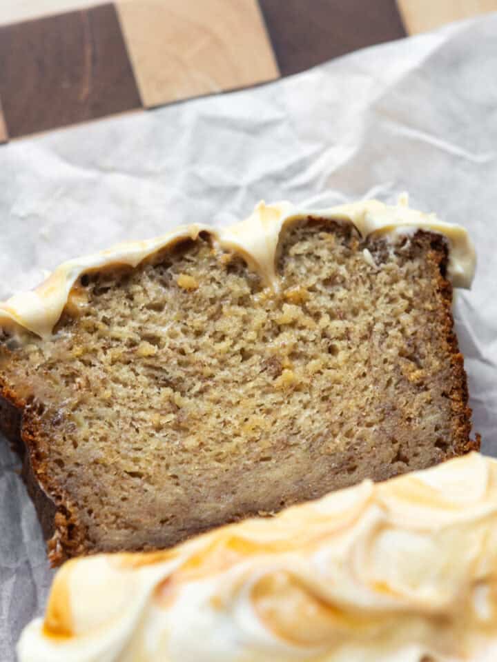 Salted caramel banana bread sliced on parchment.