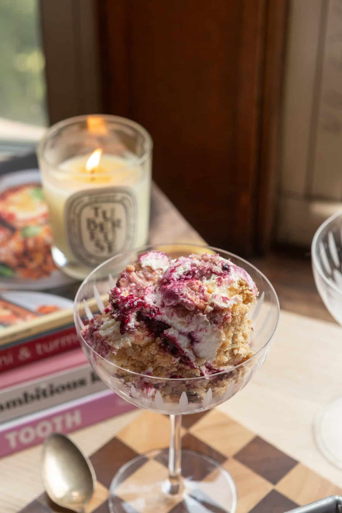 A coupe glass full of berry crumble cheesecake.