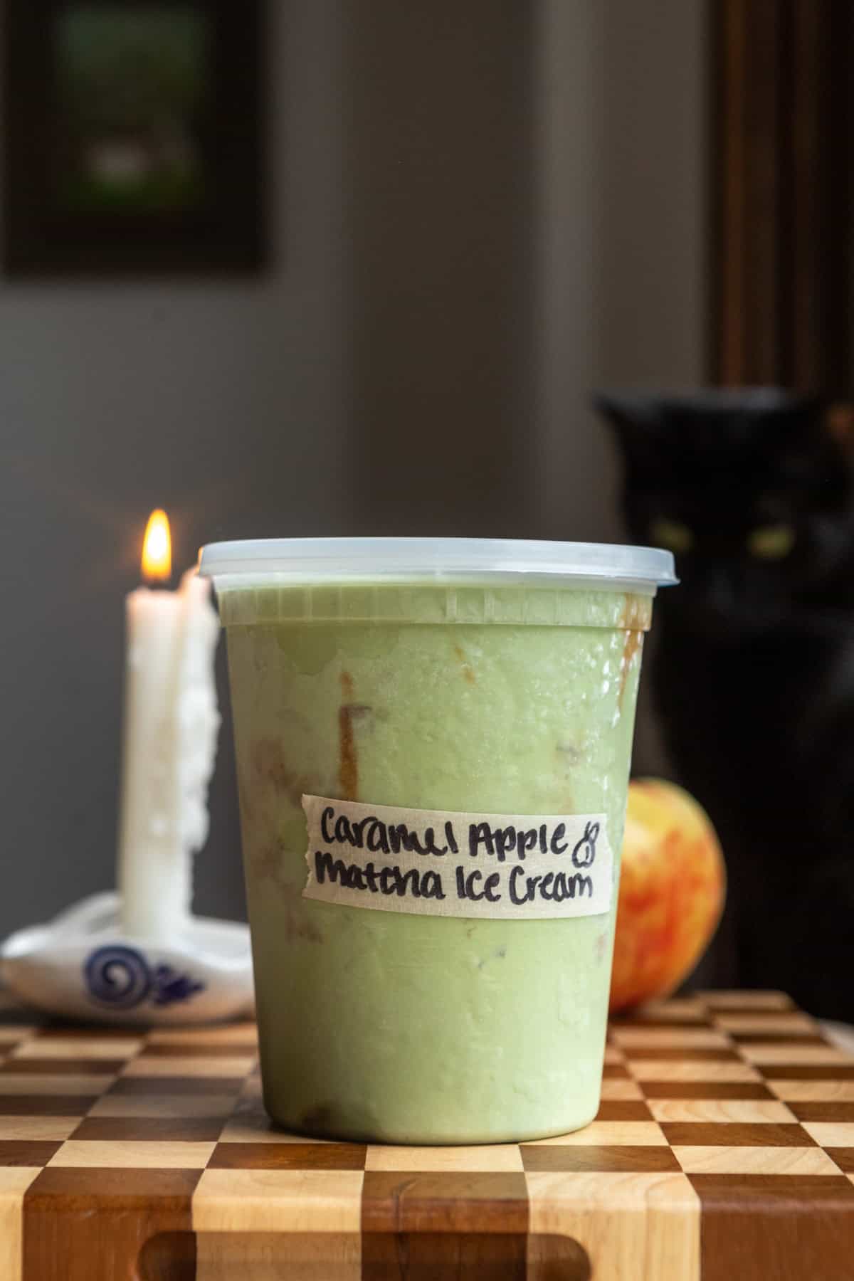 A deli container of green ice cream labelled "caramel apple matcha ice cream".