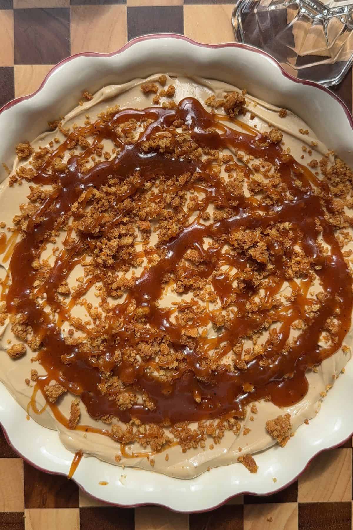 Coffee cheesecake drizzled with chai caramel sauce and gingersnap crumbles.