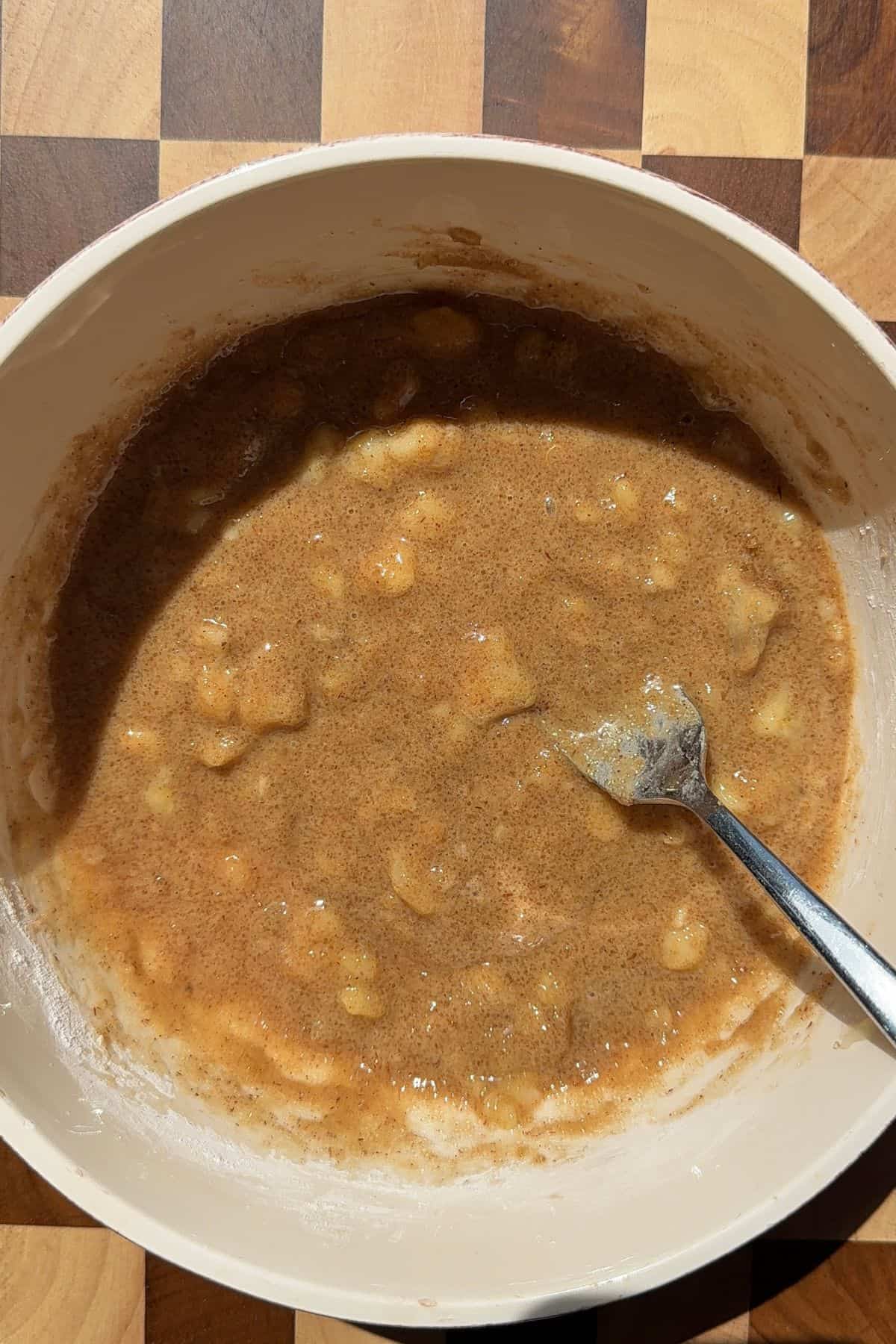 Banana bread filling in a mixing bowl with a fork.
