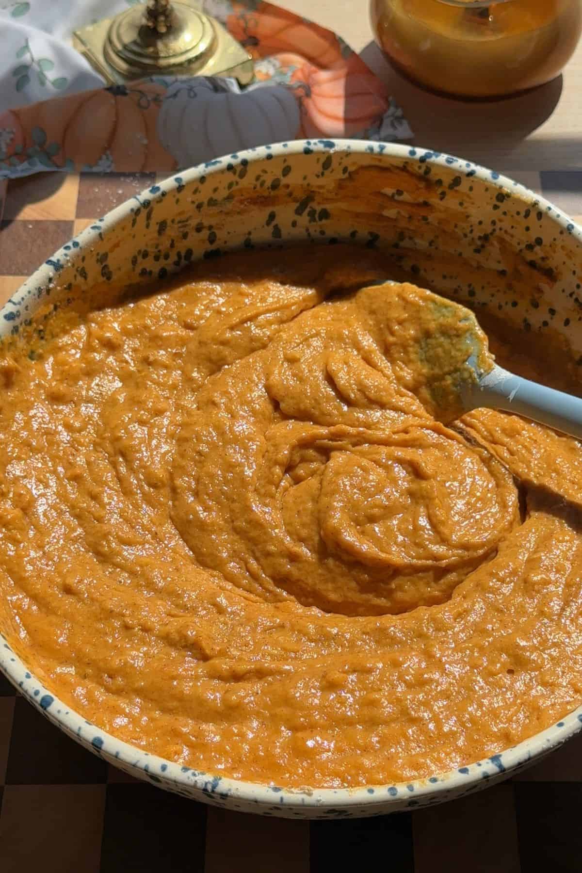 Batter in a large speckled mixing bowl with a rubber spatula.