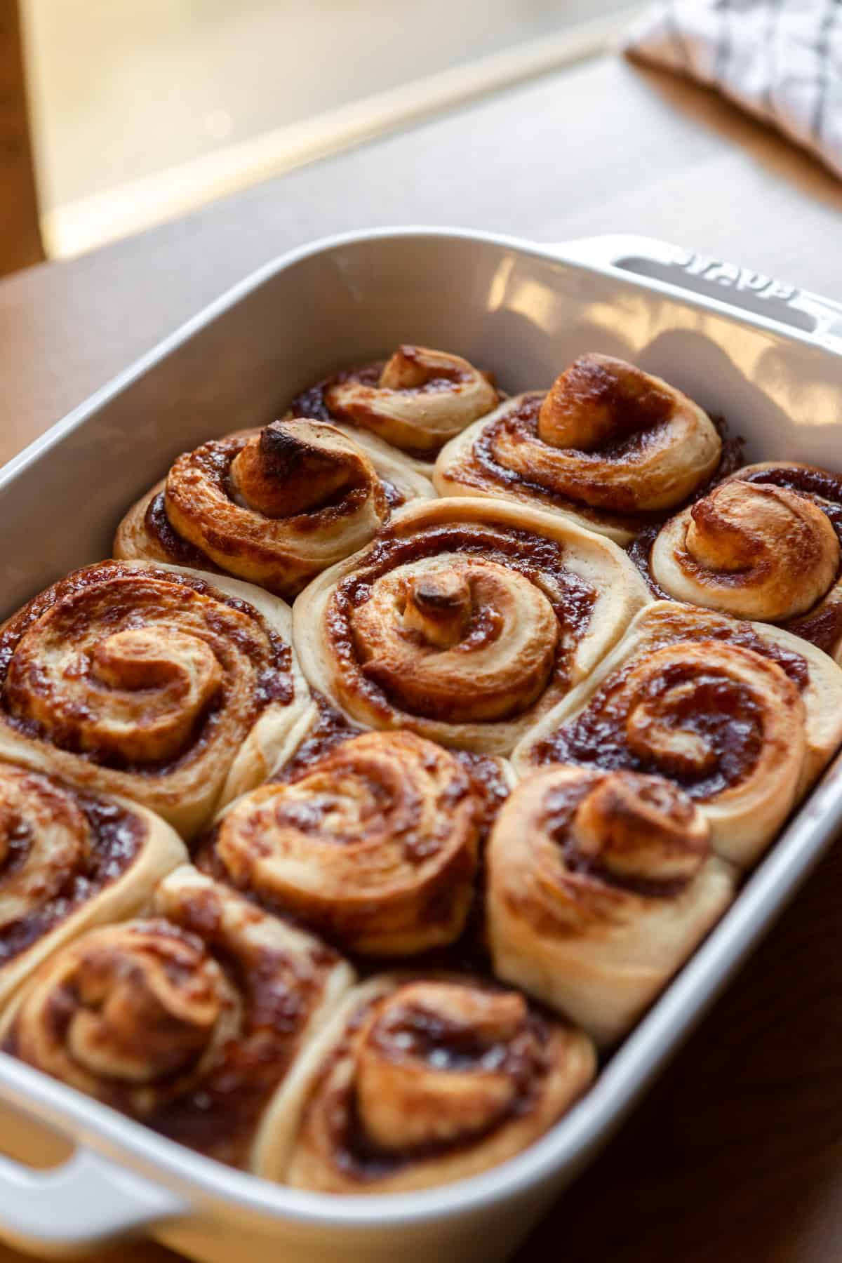 Baked apple butter cinnamon rolls in a baking dish.