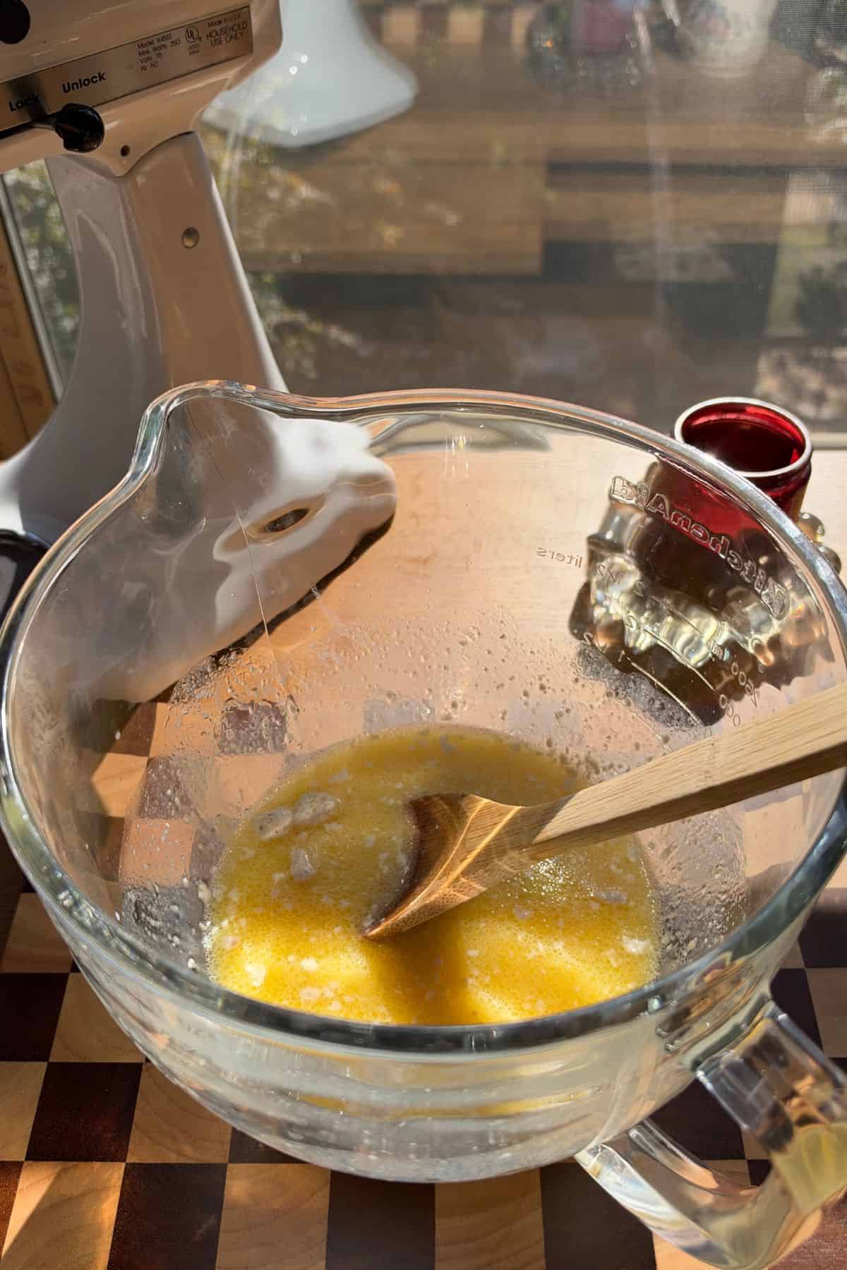Wet ingredients for cinnamon rolls in a large glass bowl.